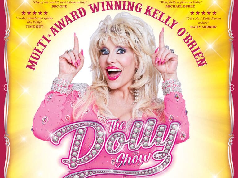 Colorful poster promoting The Dolly Show, a Dolly Parton tribute; smiling blonde performer in a pink rhinestone dress, with the glittery 'The Dolly Show' logo.